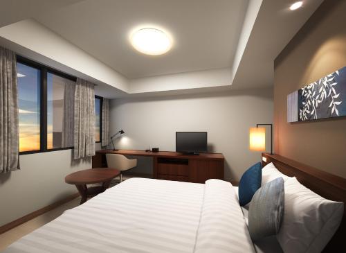 a bedroom with a bed and a desk with a computer at Axia South Cikarang Service Apartment in Cikarang