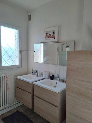 La salle de bains est pourvue de 2 lavabos, d'un miroir et d'une fenêtre. dans l'établissement Escapade confort chez Mel à Avignon, à Avignon