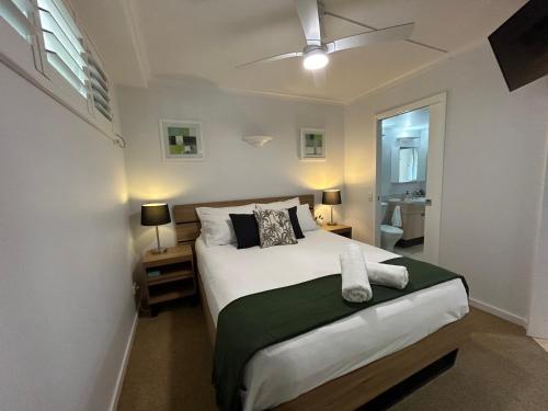 a bedroom with a large bed and a window at Apartment 12 On Trinity Beach in Trinity Beach