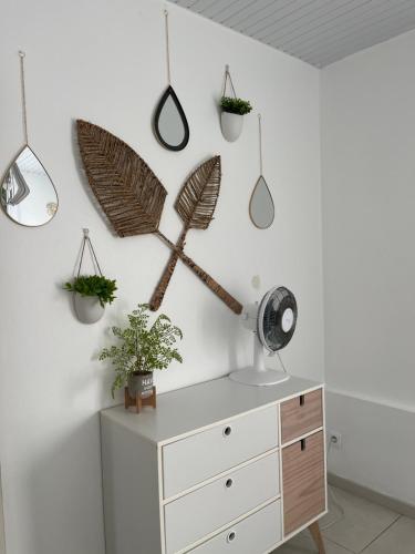 a room with a dresser and plants on the wall at Résidence Flores De Maria in Le Marin
