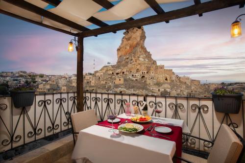 a table on a balcony with a view of a mountain at Portal Cappadocia Hotel in Ortahisar