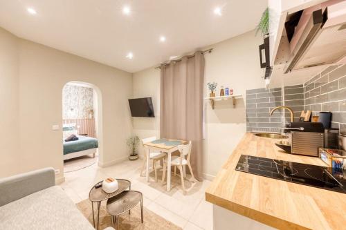 une cuisine et un salon avec une table et un canapé dans l'établissement Evasion urbaine - Au pied des Quais de Seine, à LʼÎle-Saint-Denis