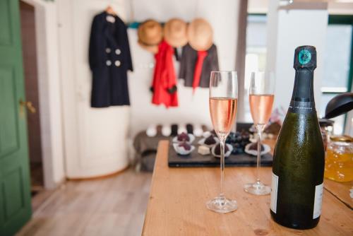 a bottle of champagne and two glasses on a table at Wine Cellar Turned Idyllic Spa Escape in Lenti