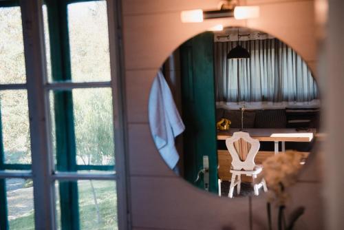 a mirror reflecting a room with a table and a chair at Wine Cellar Turned Idyllic Spa Escape in Lenti