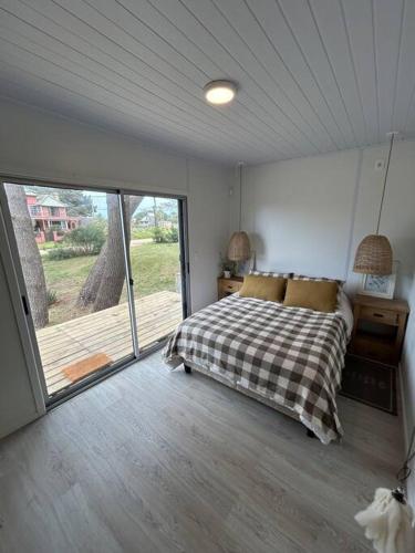 a bedroom with a bed and a large window at Nina casa de playa in Balneario Buenos Aires