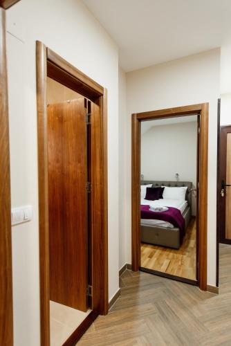 a room with a door and a bed with a mirror at Apartmani Jela Zlatar in Vukovina