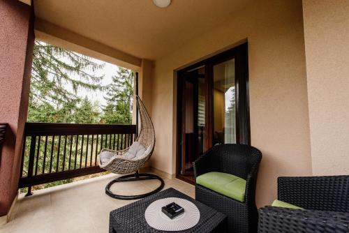 a porch with a hammock and a table and chairs at Apartmani Jela Zlatar in Vukovina