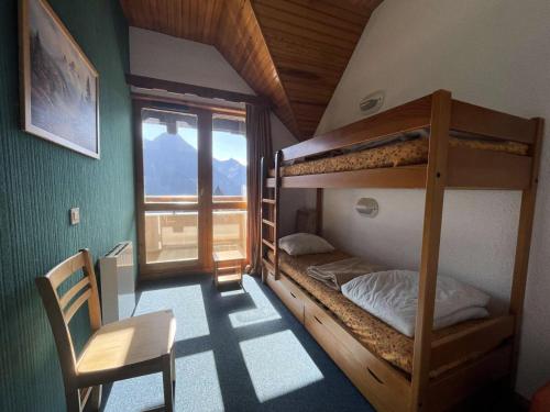 - une chambre avec des lits superposés, une chaise et une fenêtre dans l'établissement Résidence Soleil - Grand duplex lumineux de 80 m2 avec vue panoramique MAE-5471, à Vénosc