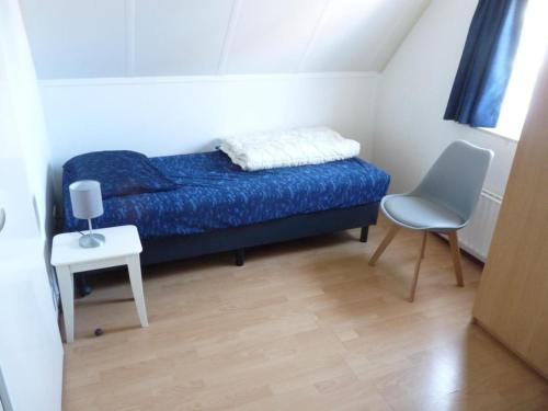 a small bedroom with a bed and a chair at Detached House Breskens near Scenic Beaches in Breskens