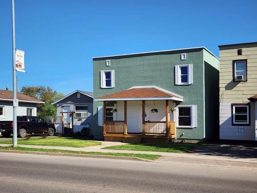 una casa verde con un portico su una strada di Near Airport Parking Netflix Wi-fi a Thunder Bay