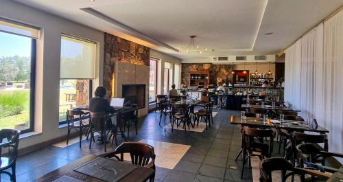 a restaurant with tables and chairs and a bar at Regency Park Hotel in Montevideo