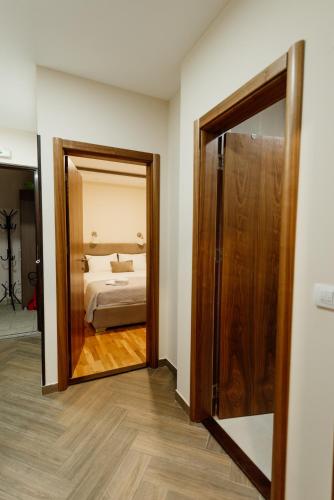 a mirror in a room with a bed and a bedroom at Apartmani Jela Zlatar in Vukovina