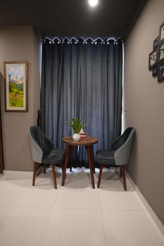 a dining room with a table and two chairs at Hotel Crossroads in Islamabad