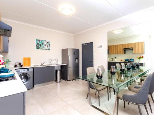 a kitchen and dining room with a glass table and chairs at Glen Haven in Midrand
