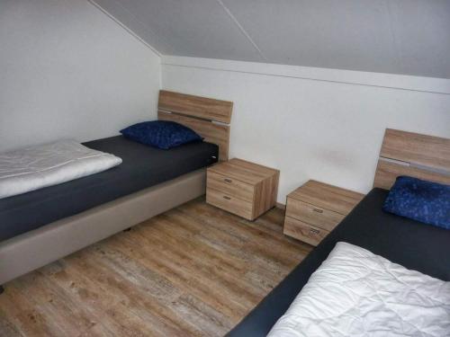 Un dormitorio con dos camas y dos mesitas de noche. en Coastal Bungalow w Garden, en Breskens