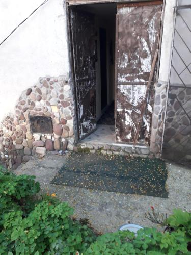 an open door of a building with a stone wall at Seosko turisticko domacinstvo Nikolic-Zivkovic selo Ljubatovica in Čiflik