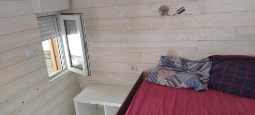 une petite pièce avec un lit et une fenêtre dans l'établissement Vacances en bord de mer, au Grau-dʼAgde