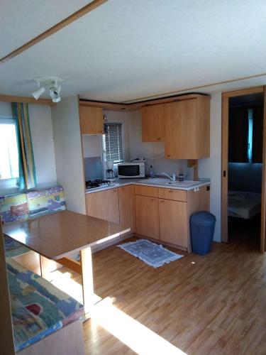 une cuisine avec des armoires en bois et une table à l'intérieur dans l'établissement Vacances en bord de mer, au Grau-dʼAgde