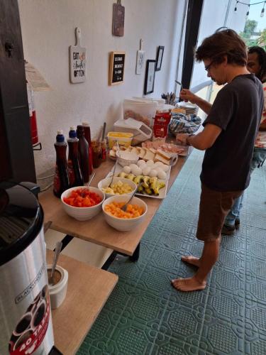 a man standing in front of a table with food at Tequila Sunrise Hostel in Guatemala