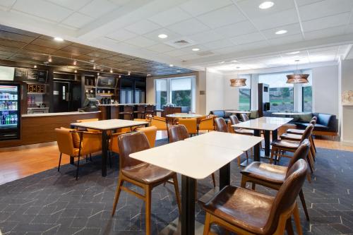 a restaurant with tables and chairs and a bar at Courtyard by Marriott State College in State College