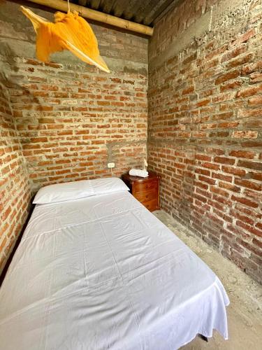 a bedroom with a bed in a brick wall at Finca el Morichal in Buga