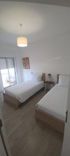 a bedroom with two beds and a window at BeachCity Guesthouse in Lagos