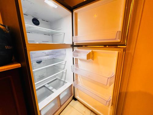 an empty refrigerator with its door open in a kitchen at Cozy Walkout Basement with Tranquility in Toronto