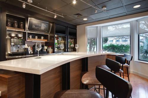 a bar with a large white counter and some chairs at Courtyard by Marriott State College in State College