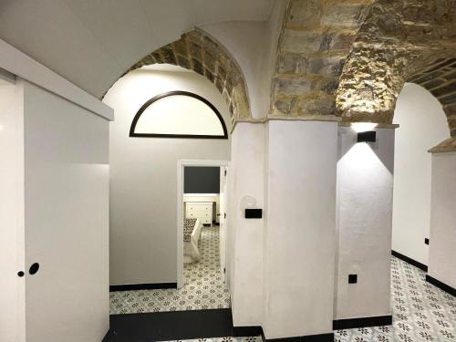 a hallway with white walls and a ceiling with a window at Apartamento Plaza del Cabildo II - Sanlúcar Centro in Sanlúcar de Barrameda