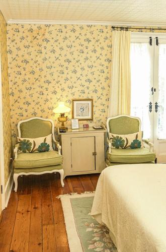 a bedroom with two chairs and a bed and a table at Historic Wilson-Guy House in Niagara on the Lake