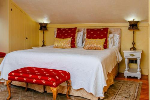 a bedroom with a large white bed with red pillows at Historic Wilson-Guy House in Niagara on the Lake