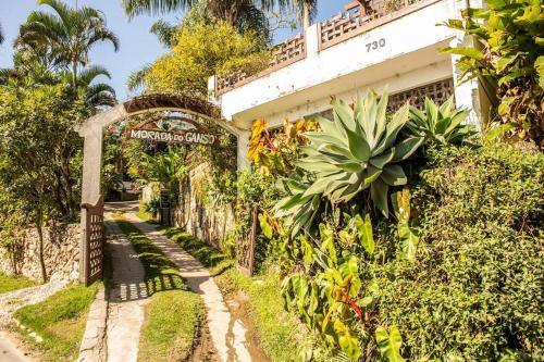 an entrance to a house with an arch and plants at 8 - Studio Vista Mar - Morada do Ganso in Bombinhas