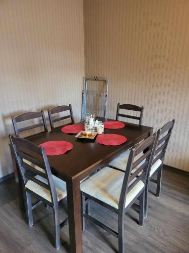 a dining room table with red plates and chairs at Astoriq in Sofia