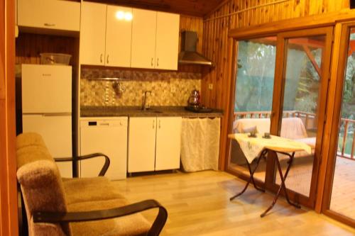 een keuken met witte kasten, een stoel en een tafel bij Garden Party House in Sile