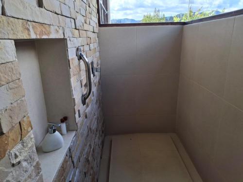 a bathroom with a shower built into a brick wall at Sumangá Hotel Boutique in Sutatausa