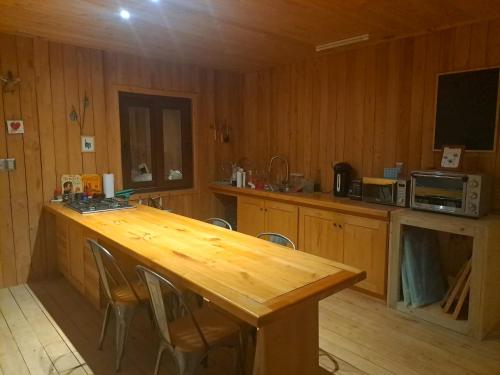 a kitchen with a wooden table with chairs and a television at La gran escapada in Navidad
