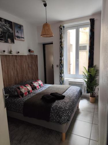 une chambre avec un lit et une grande fenêtre dans l'établissement Le temps des cerises, à Nîmes