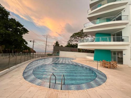 a swimming pool in front of a building at Apartamentos Mi Reserva OK - Fontaine Bleu in Coveñas