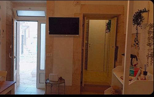 un salon avec une télévision au mur dans l'établissement La Casetta di Francy, à Martina Franca