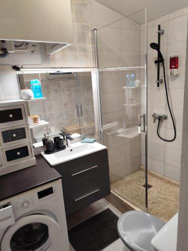 une salle de bain avec douche et lavabo et une machine à laver dans l'établissement Le temps des cerises, à Nîmes