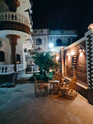 a patio with a table and chairs at night at Ramsses Palace in Luxor