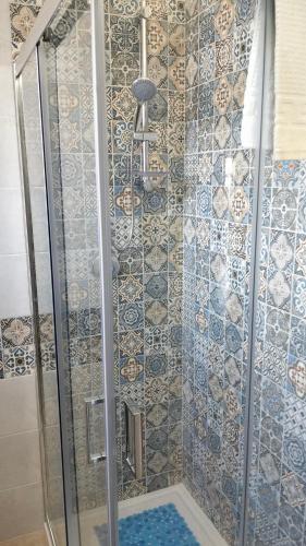 a shower with blue and white tiles on the wall at Villa Leo in Ostuni