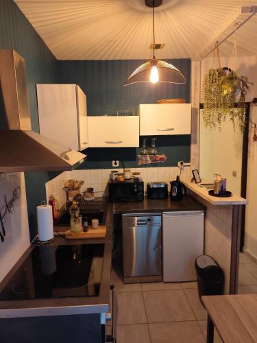 une cuisine avec des armoires blanches et un four à plaques de cuisson dans l'établissement Le temps des cerises, à Nîmes