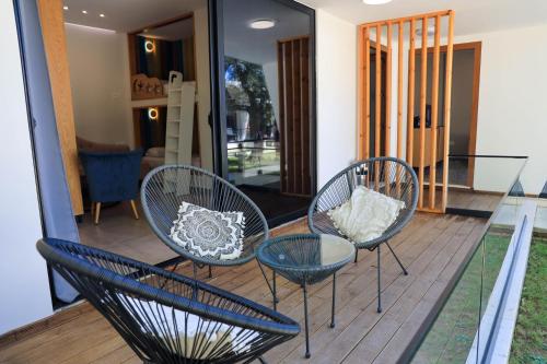 three chairs and a table on a deck at Luna Mare Boutique Seaside in Borsh