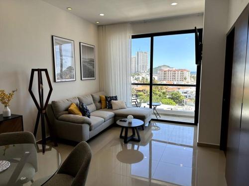a living room with a couch and a table at Cómodo departamento en Mazatlán in Mazatlán
