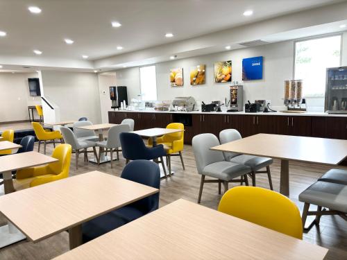 a dining room with tables and yellow chairs at Comfort Inn Marietta-Atlanta near Ballpark-Galleria in Marietta