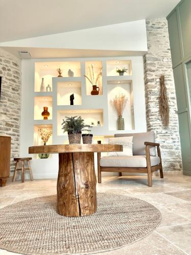 un salon avec une table en bois et des plantes en pot dans l'établissement La Fleur de Sauzelle, à Saint-Georges-dʼOléron