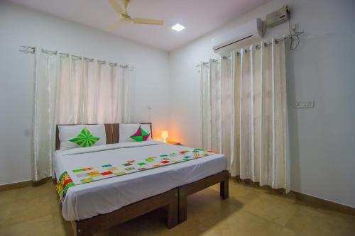 a bedroom with a bed and a lamp in it at Super Collection O Holy Cross Home Stays in Goa