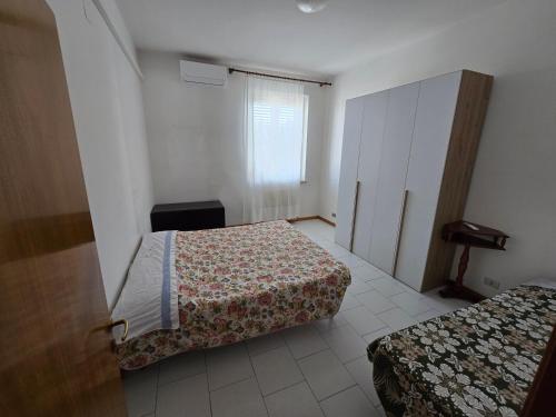 a hotel room with two beds and a window at Appartamento Mare in San Benedetto del Tronto