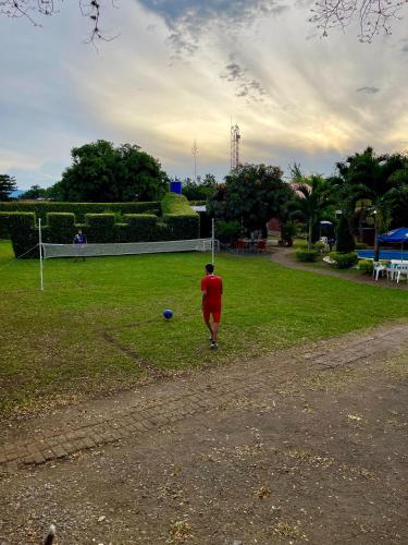 a man walking in a field with a soccer ball at Finca el Morichal in Buga